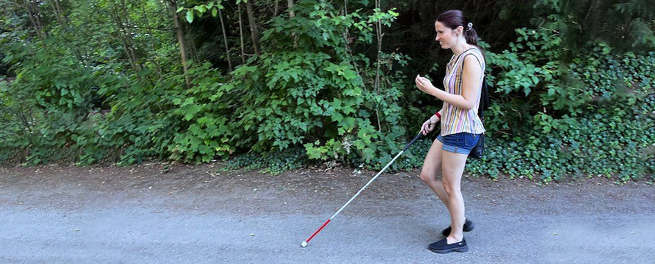 A woman with a visual impairment walking along an accessible trail