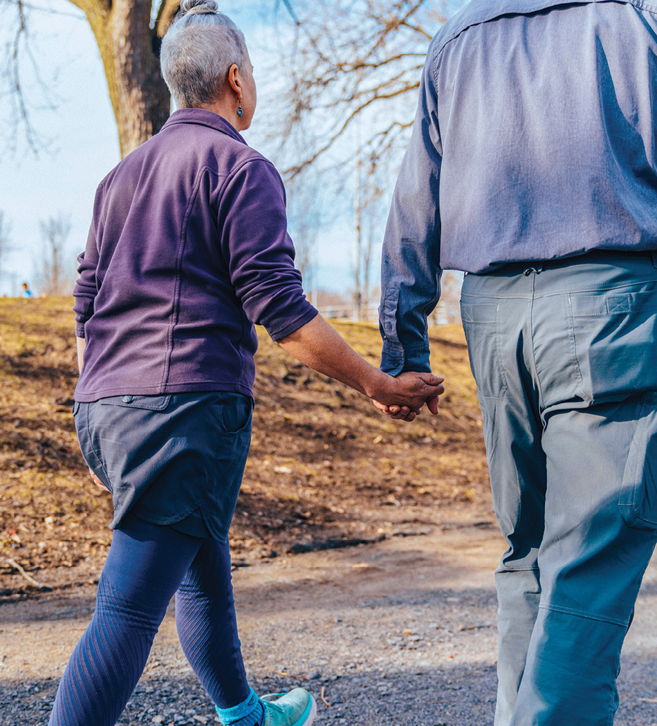 Two adults walking holding hands