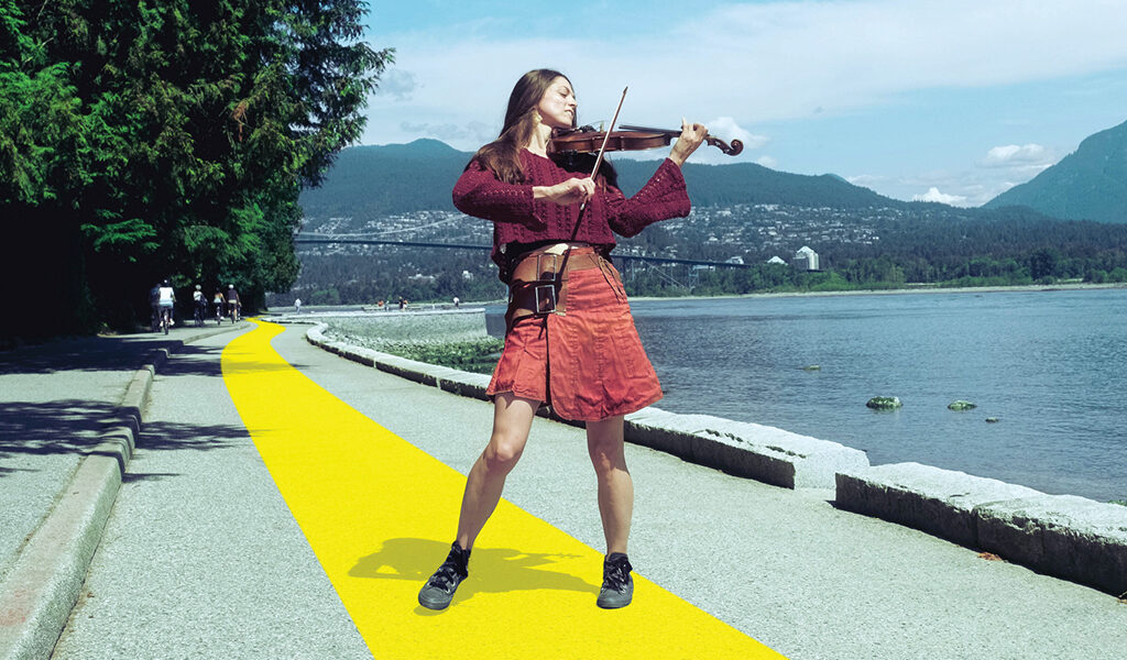 Une femme debout sur une ligne jaune sur le sentier Transcanadien jouant du violon pour la campagne On y va!