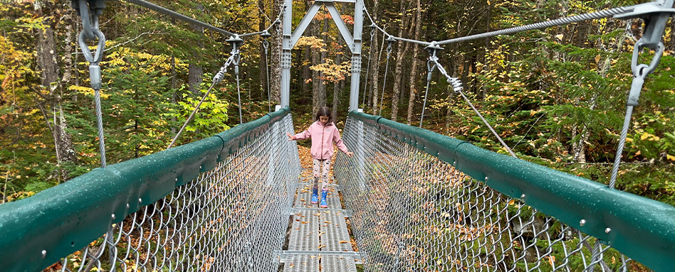 A child walking across a bridge at the Sentier Louise-Gasnier