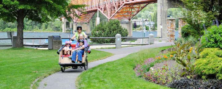 A family riding a trishaw (a three wheel bike) along a trail