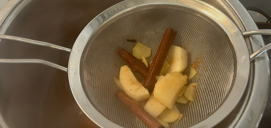 ginger and apple slices being drained into a thermos