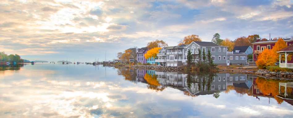 Vibrant lakeside houses with cloudy sky at Mahon Bay | Maisons vibrantes au bord du lac avec ciel nuageux à Mahon Bay