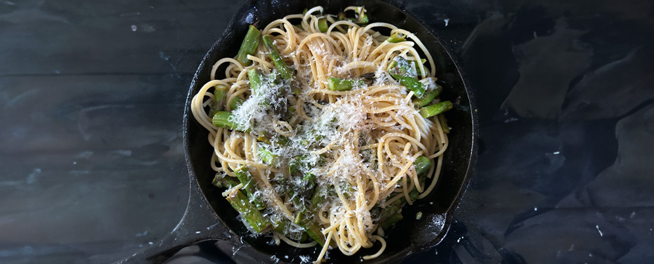 A skillet filled with asparagus pasta | Une poêle remplie de pâtes aux asperges.