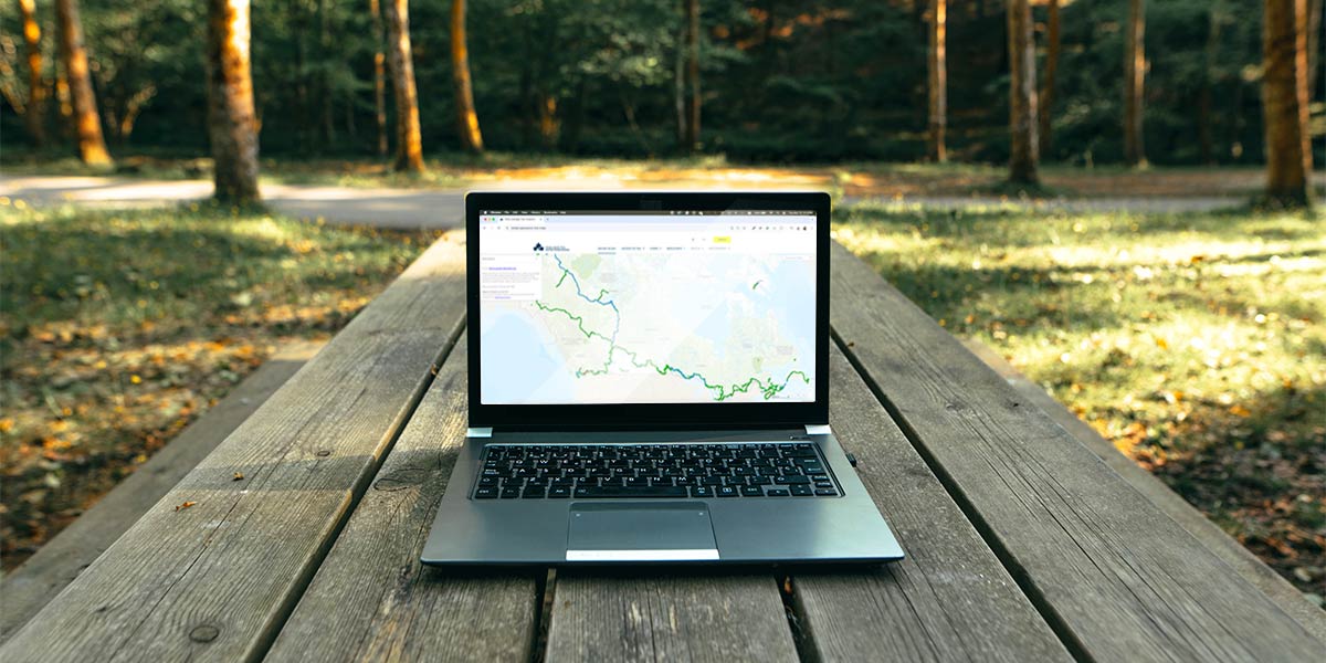 A laptop screen displaying the Trans Canada Trail map, illustrating how to use it effectively. Un écran d'ordinateur portable affichant la carte du Sentier transcanadien, illustrant comment l’utiliser efficacement.