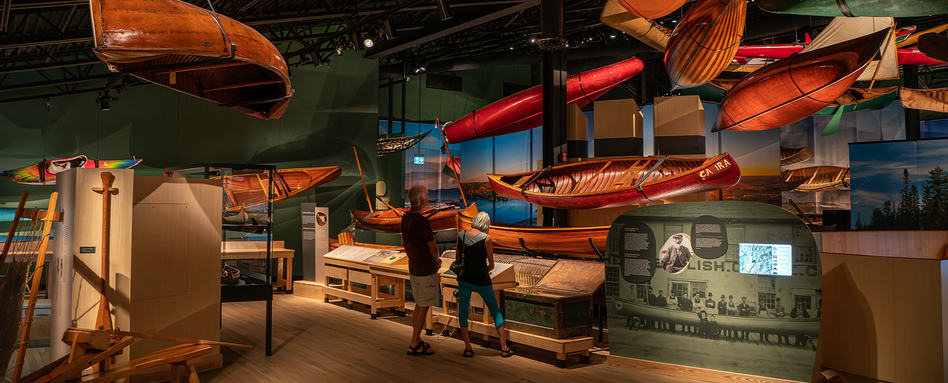 people looking at hanging canoes