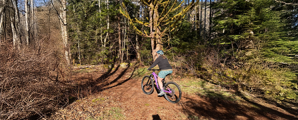 woman biking on a dirt path