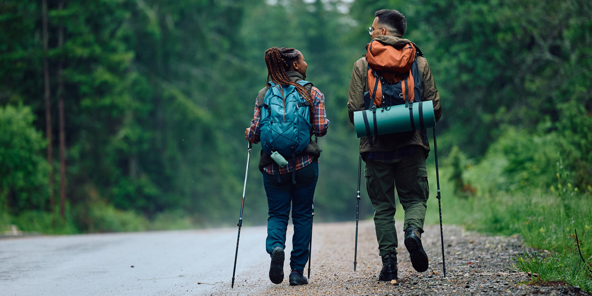 two people in hiking gear chatting on a trail
