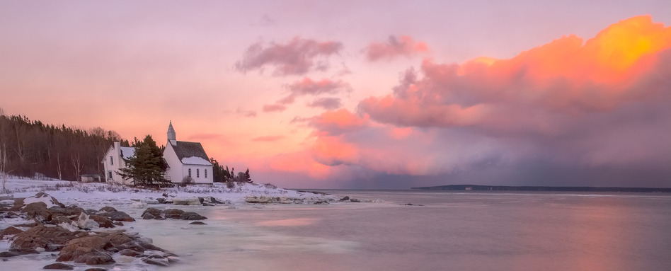sunset overlooking water and small house on land