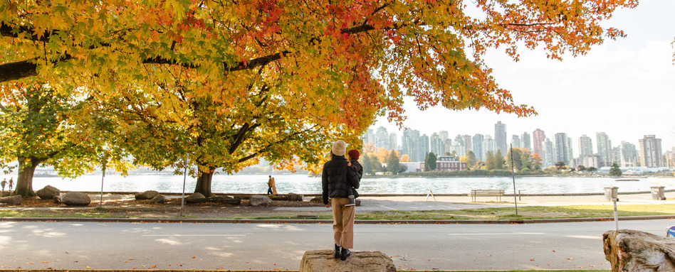 Stanley Park in the fall | Sentier Transcanadien woman and baby looking at fall leaves overlooking trees and city