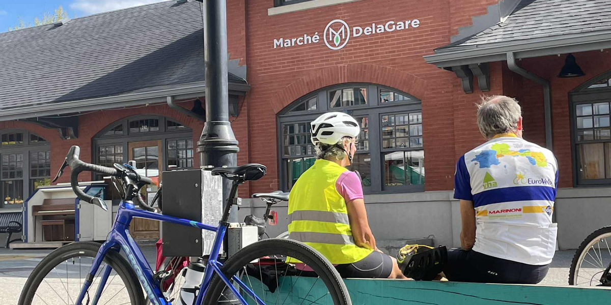 00Feature image_QC_story_boucle-en-estrie-et-dénivelés_grandes-fourches_claude-plante-05 | Sentier Transcanadien people sitting on bikes infront of a store