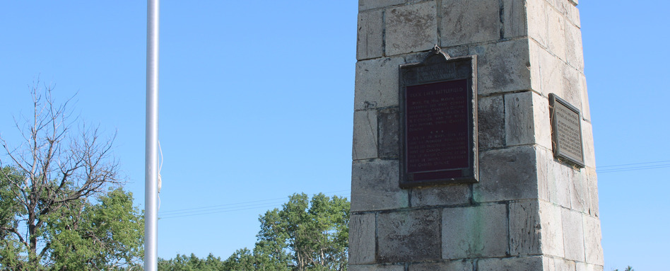 plaque on a wall with blue skies and trees behind