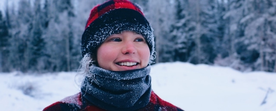 woman smiling in winter gear in teh snow