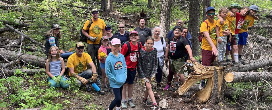 group of people standing in a forest smiling