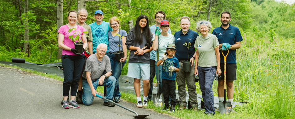 people standing on a trail with shovels smiling