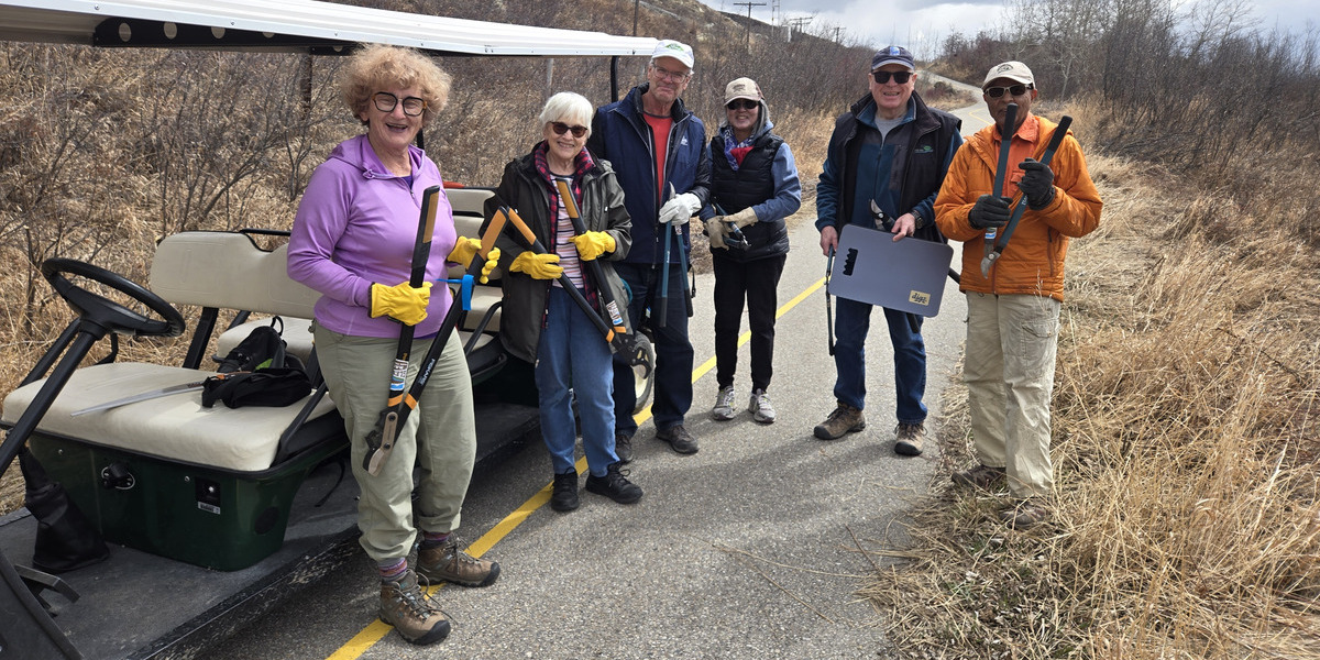 00Feature image_SF107815_AB_Trail-Care-2025-Glenbow-Ranch-Park-Foundation | Sentier Transcanadien people smiling holding hedge trimmers on a paved road