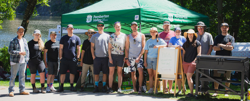 group of people standing infront of a green tent smiling