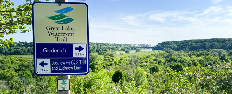 trail signage overlooking grassy area on a sunny day