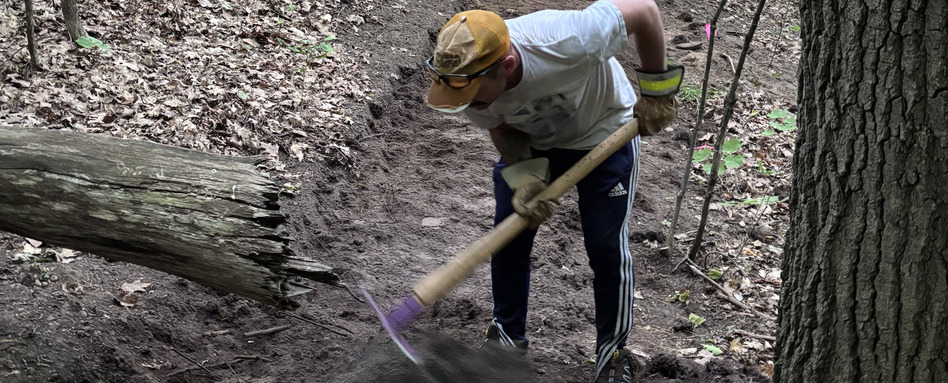 person digging in dirt pathway