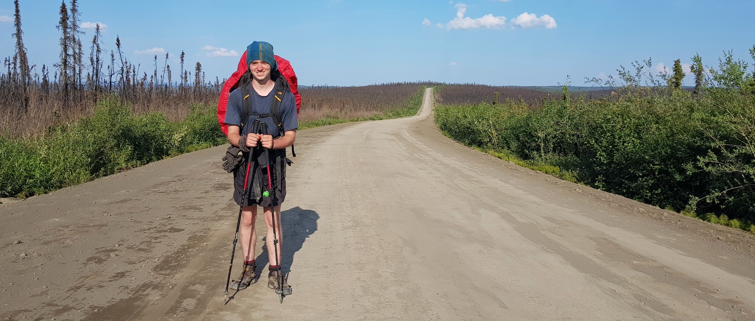 Aidan Beckett stops for a photo on a gravel trail.
