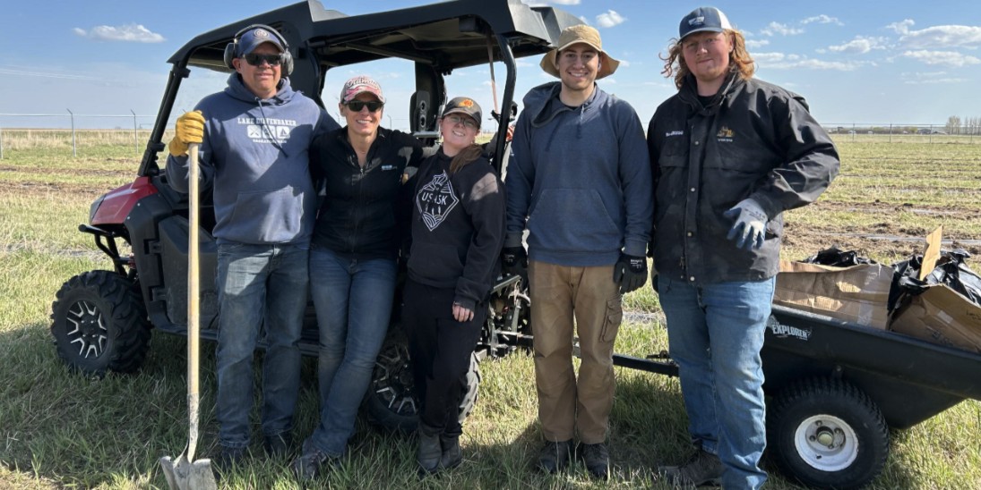 00Feature story_SK_PTP_Prairie Sky Trails Association_Planting 3-2025 | Sentier Transcanadien group of people standing infront of cart holding tree planting gear on a sunny day