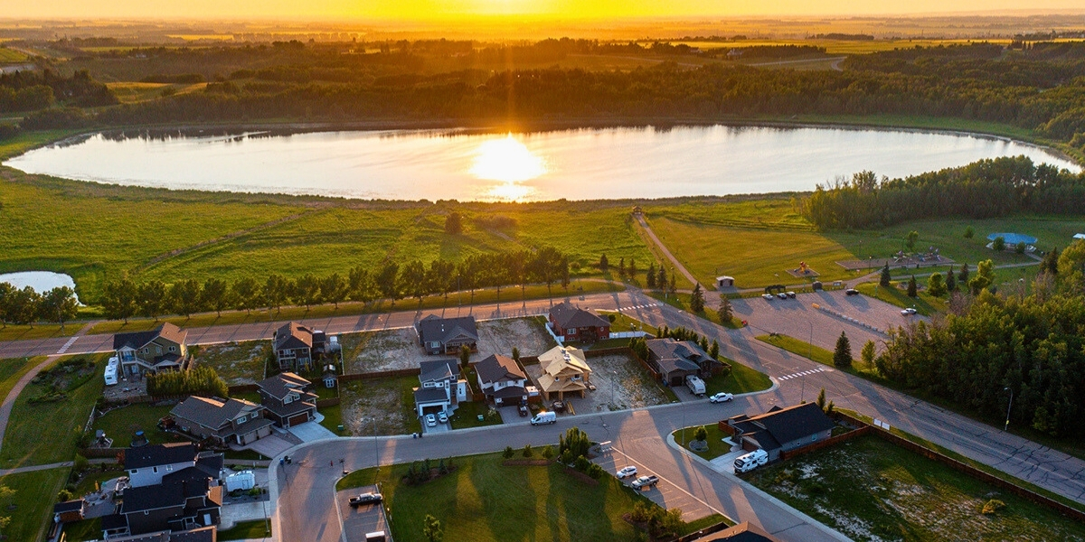00Feature image_AB_Town of Innisfail Trail_credit Town of Innisfail | Sentier Transcanadien sunset overlooking a town and lake birdseye