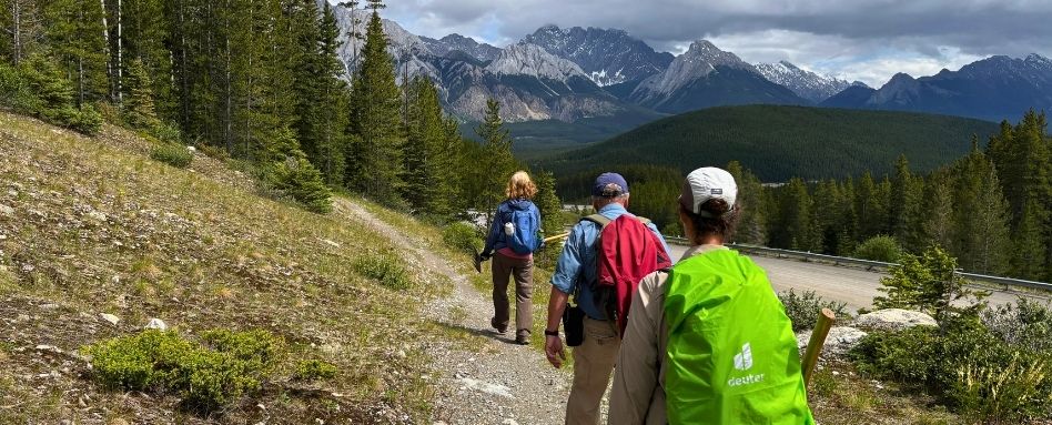 group of hikers on hike with mountains in the foreground