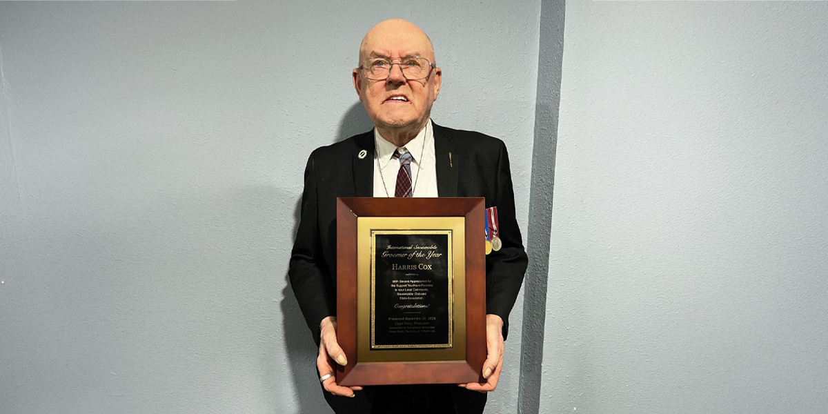 man in a suit holding an honorary plaque