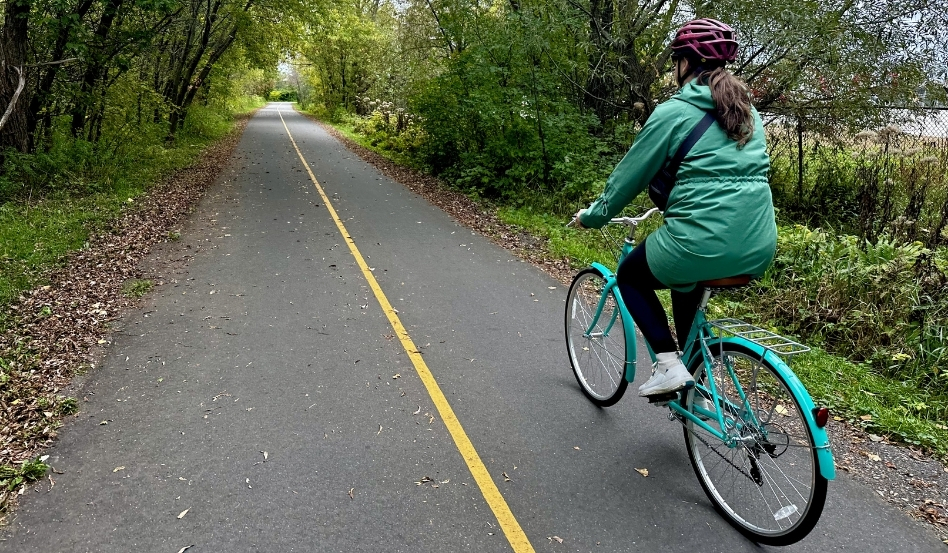 woman biking on paved trail