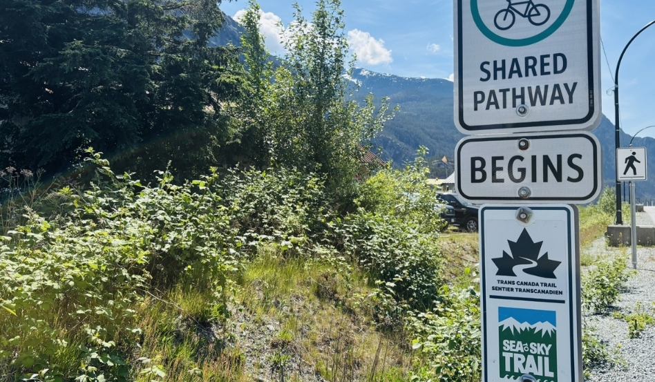 trail signage with mountain and forest behind