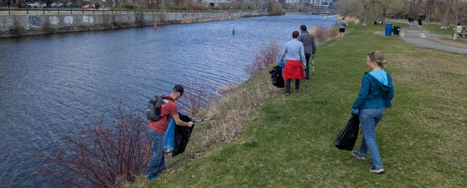 people walking alongside riverway cleaning up trash