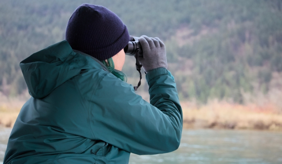 02Support image_Taryn Eyton Leave No Trace_credit Taryn Eyton | Sentier Transcanadien person using binoculars looking out to lake and forest