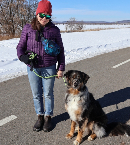 woman walks with dog on a snowy day