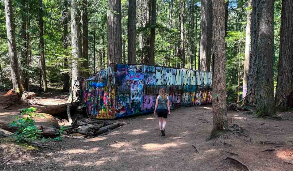 04Support image_Whistler Museum_alternate_Trainwreck_credit Taryn Eyton | Sentier Transcanadien woman walking around forest train wreck