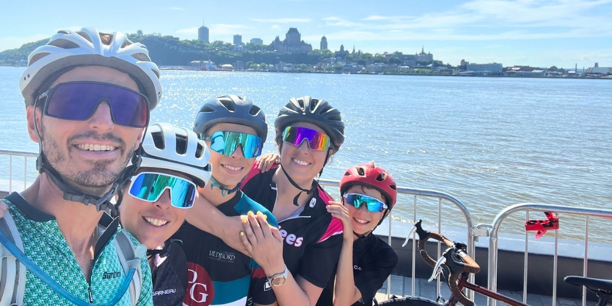 group family selfie in biking gear infront of water and skyline
