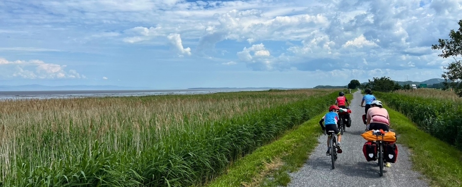 01Support image_Web story_Pat Lee_credit Alex Genest | Sentier Transcanadien family cycling along gravel trail in a field