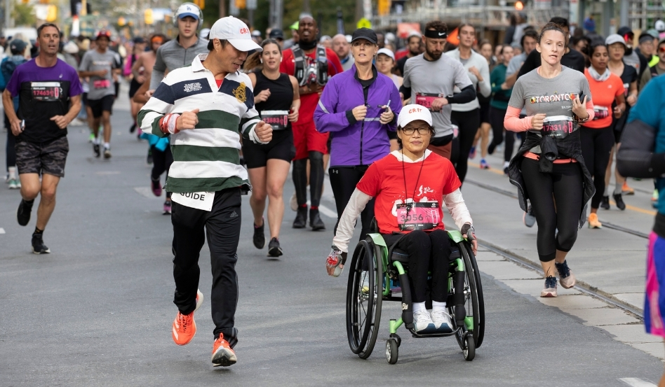 02Support image_Jen Cerullo profile_credit Canada Running Series | Sentier Transcanadien person jogging alongside person in a wheelchair