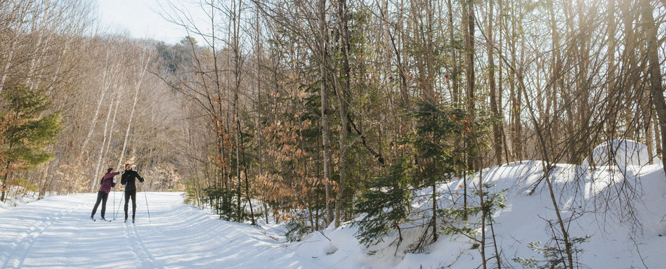 two people walking on a snow covered trail