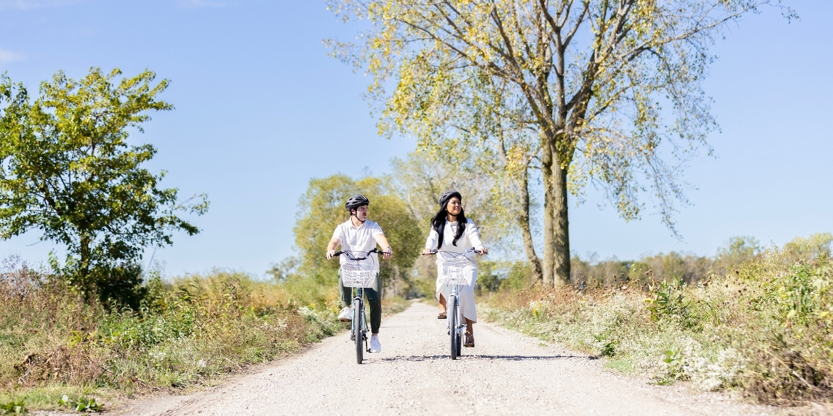 00Feature image_Pelee Island trail profile_credit Tourism Windsor Essex Pelee Island | Sentier Transcanadien two people riding a bike on a paved trail on a sunny day