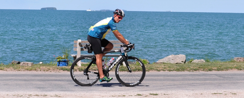 01Support image_ON_Pelee Island trail profile_credit Simon Wilson 1 | Sentier Transcanadien man riding a bike lakefront on a sunny day