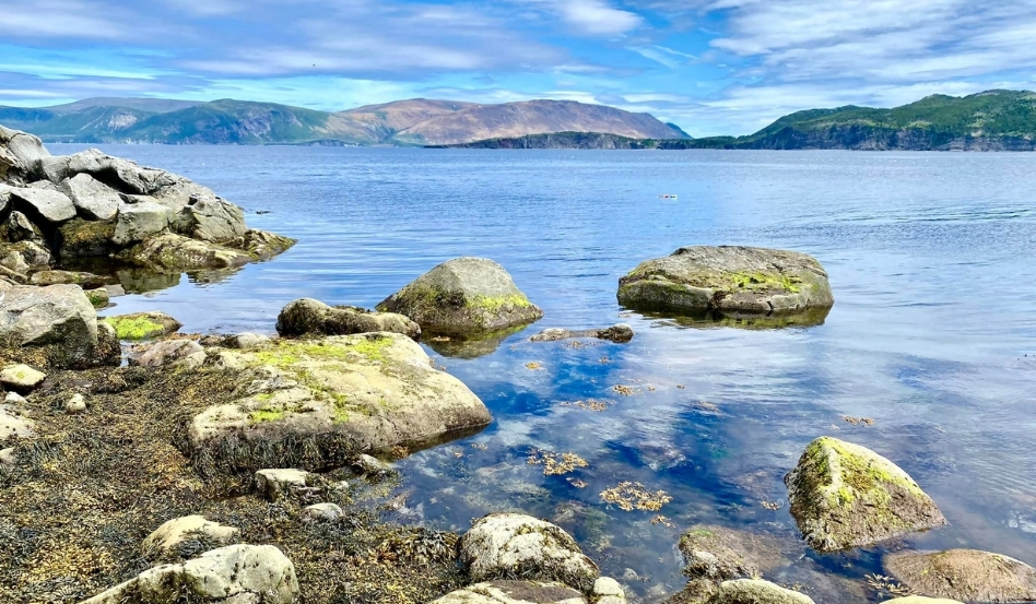 04Support image_NLITA_Bay of Islands_credit Cabox Geopark | Sentier Transcanadien large boulders in waterfront with rolling mountains behind