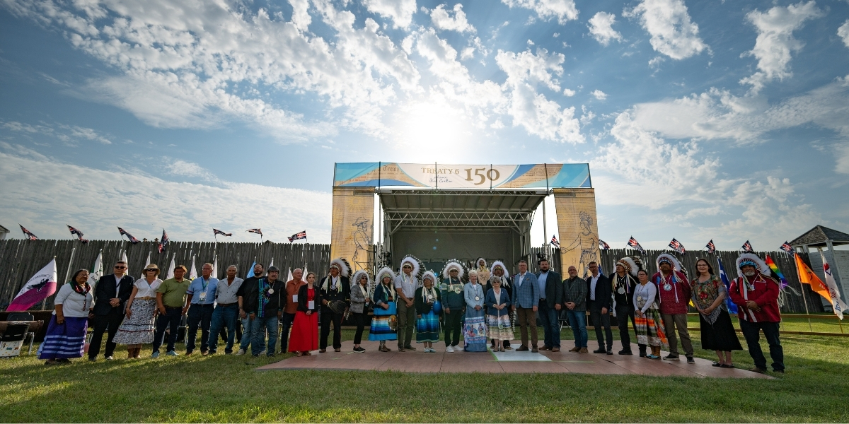 A large group standing in front of a Treaty 150 sign