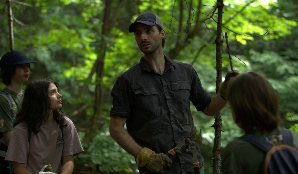 people conversing in a forested area